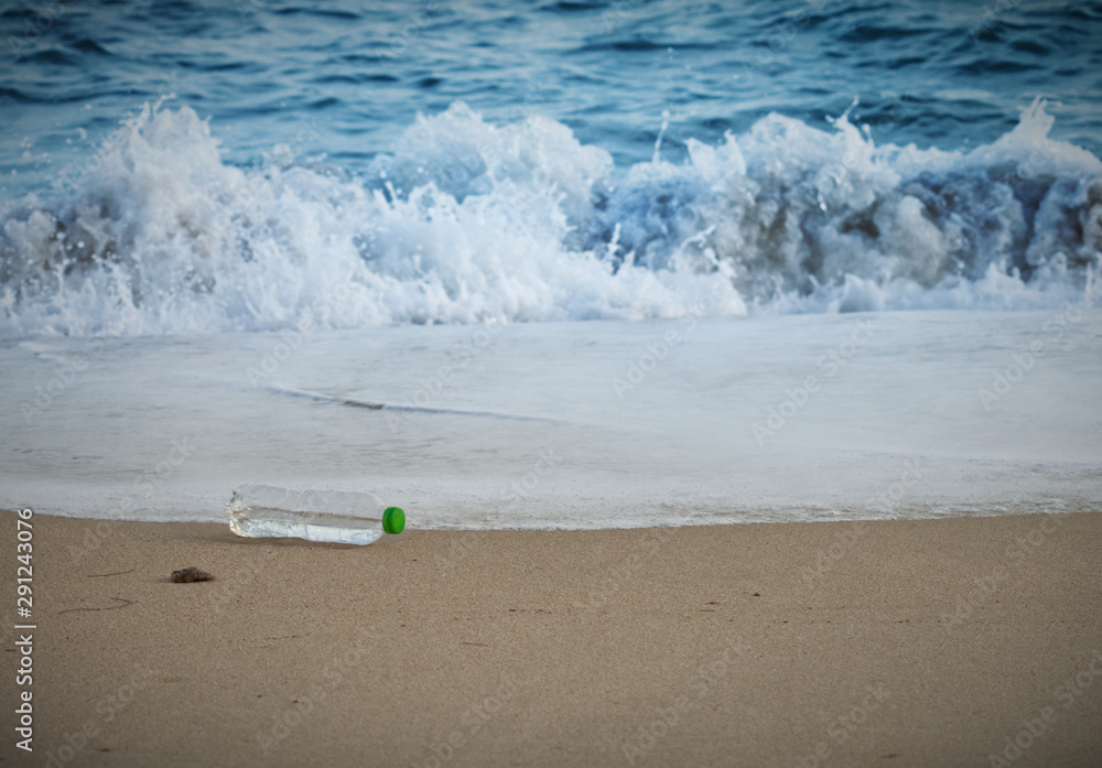 Plastic water bottle being dumped on the beach Plastic water bottle being dumped on the beach