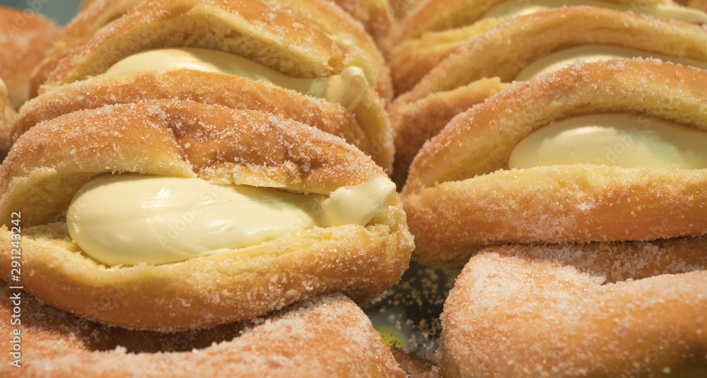 soft donuts made with leavened dough, filled with custard and covered with sugar soft donuts made with leavened dough, filled with custard and covered with sugar