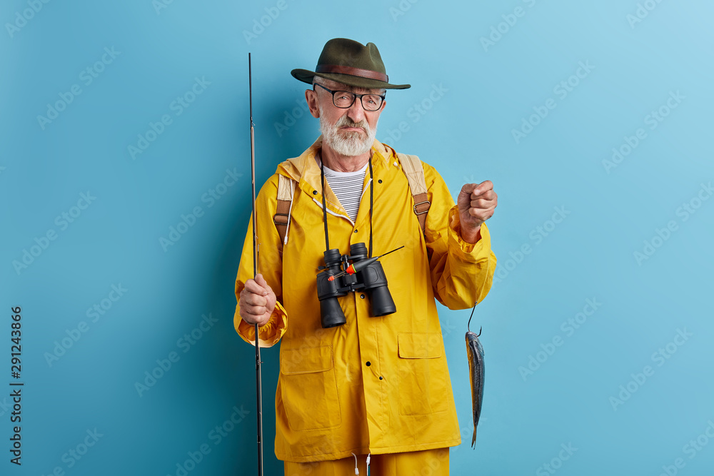 depressed old man is crying . he couldn't catch many fish, close up photo. isolated blue background, studio shot depressed old man is crying . he couldn't catch many fish, close up photo. isolated blue background, studio shot