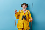 laughing smiling funny granny has cougfht fish for his wife, family, close up photo. luck, close up photo. isolated blue background, positive feeling and emotion