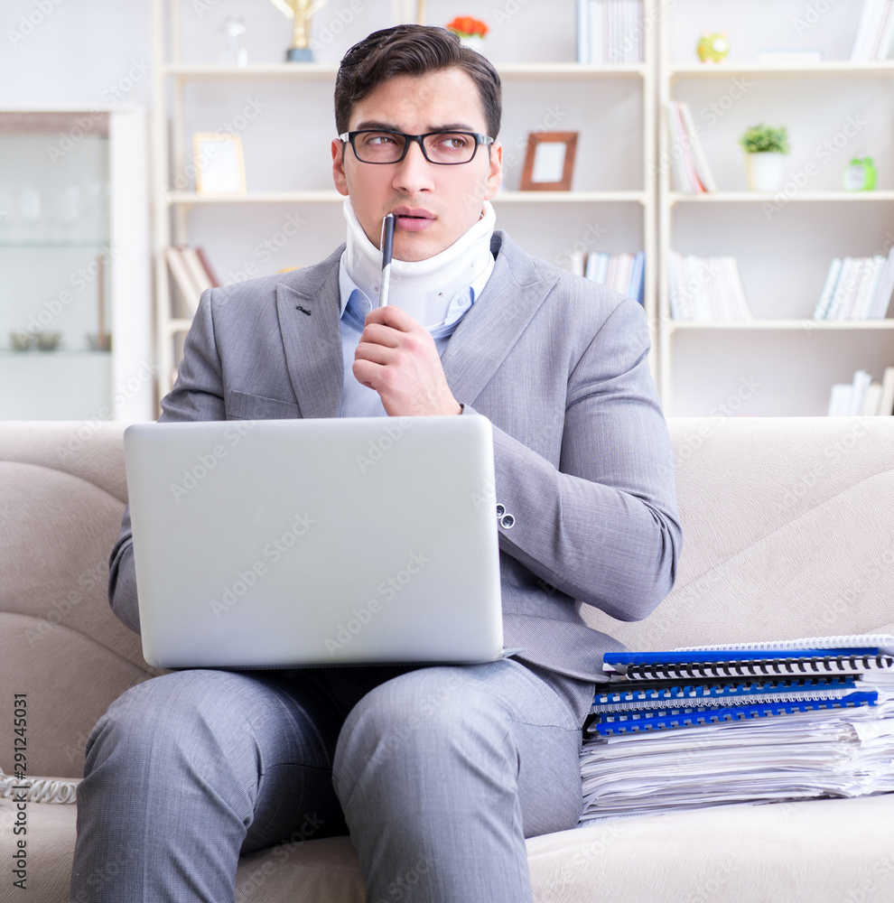 Man in neck brace cervical collar working from home teleworking Man in neck brace cervical collar working from home teleworking