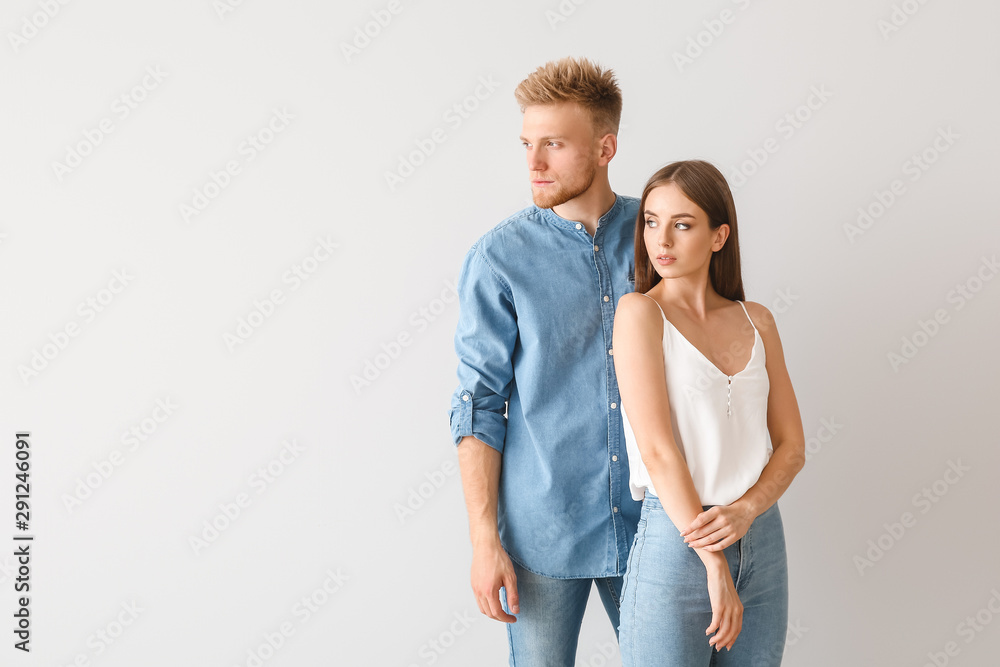 Young couple in stylish casual clothes on light background Young couple in stylish casual clothes on light background