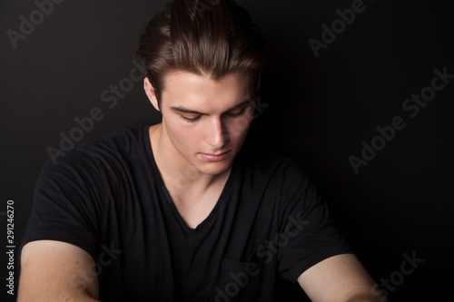 feeling lonely, teenage male on black background