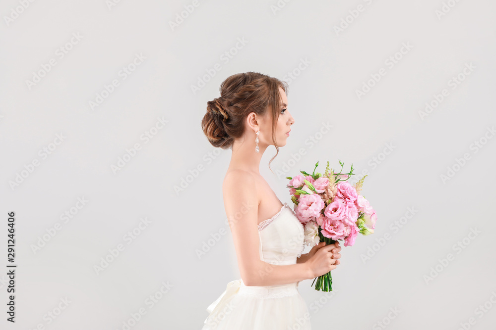 Portrait of beautiful young bride with wedding bouquet on light background Portrait of beautiful young bride with wedding bouquet on light background