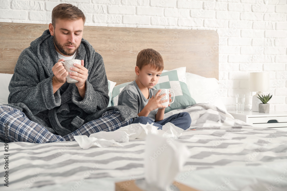 Obraz premium Father and his little son ill with flu at home