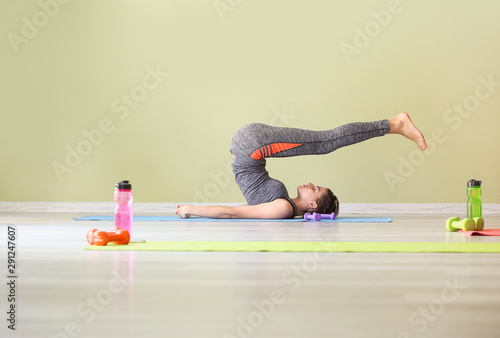 Young woman practicing yoga...