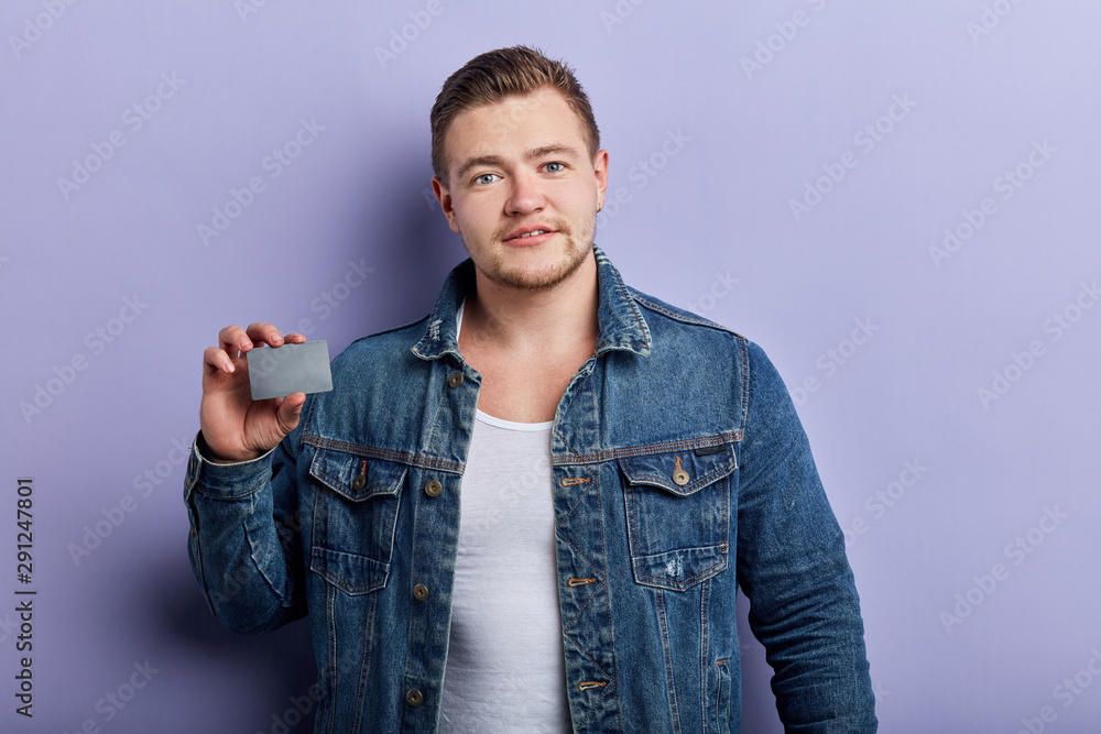 awesome good looking strong man advertising bonus card. close up portrait, isolated blue background.man going to pay by credit card, guy doing shopping awesome good looking strong man advertising bonus card. close up portrait, isolated blue background.man going to pay by credit card, guy doing shopping