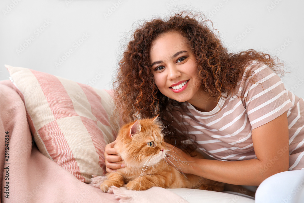 Young African-American woman with cute cat at home Young African-American woman with cute cat at home