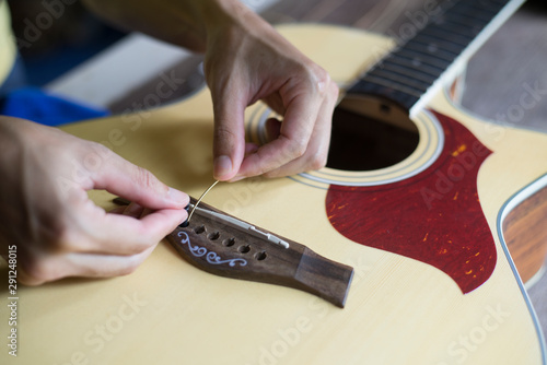 Change the acoustic guitar strings, Step to insert guitar string into the hole, Close-up photo