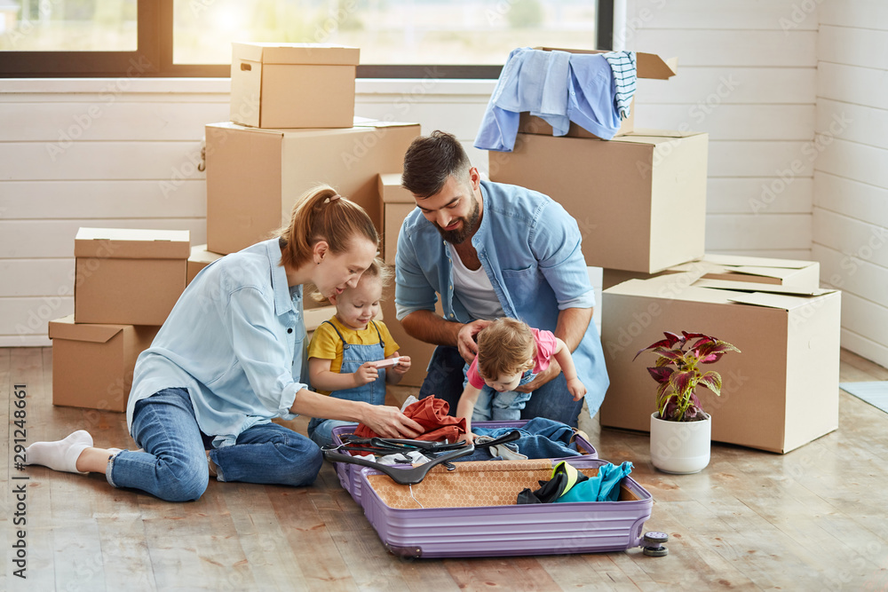 Happy caucasian family sit on floor, unpack suitcase in new house. Behind them carton boxes, wall, window. Man put hands girl who interested in unpacking. Near them flower in a pot Happy caucasian family sit on floor, unpack suitcase in new house. Behind them carton boxes, wall, window. Man put hands girl who interested in unpacking. Near them flower in a pot