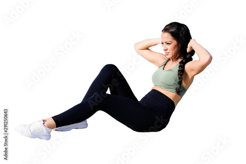 Beautiful young woman doing exercises on the floor to strengthen her muscles, studio portrait on white