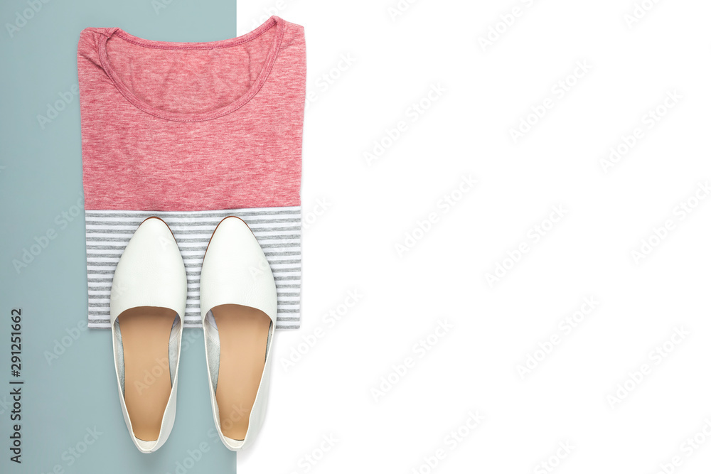 Minimalistic flat lay composition of female shirt and shoes on on blue and white background with space for text Minimalistic flat lay composition of female shirt and shoes on on blue and white background with space for text