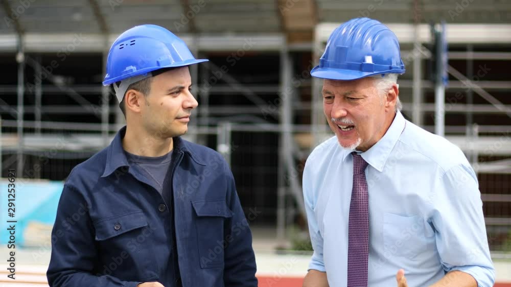 Senior engineer blaming his colleague for delay in construction site Senior engineer blaming his colleague for delay in construction site