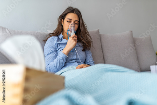 Woman holding a mask nebulizer inhaling fumes spray the medication into your lungs sick patient. Self-treatment of the respiratory tract using inhalation nebulizer