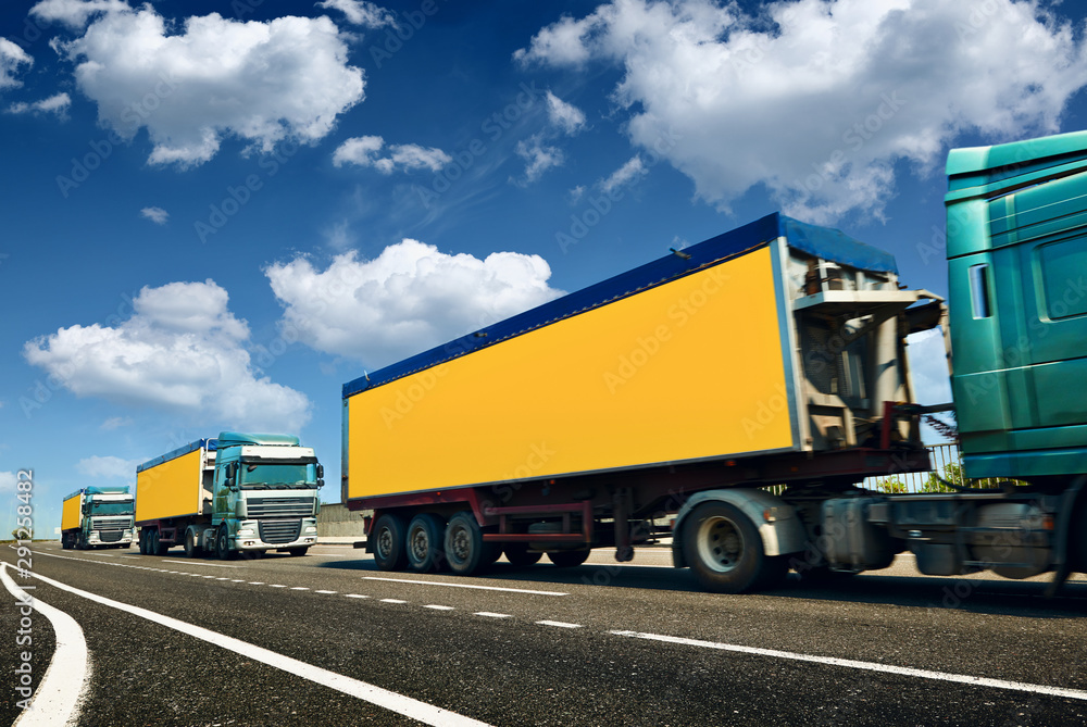Yellow trucks is on highway - business, commercial, cargo transportation concept, clear and blank space on the side view
