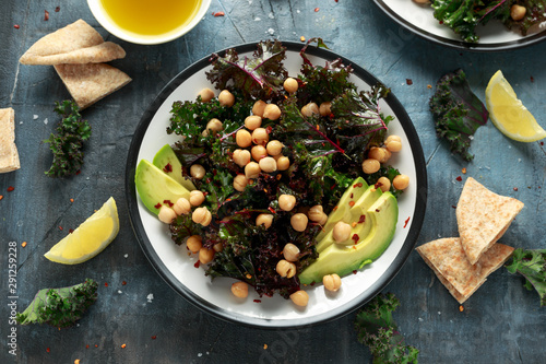 Kale Chickpeas, avocado salad with lemon on plate. healthy food.