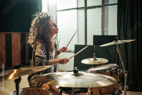 Foto Woman playing drums during music band rehearsal