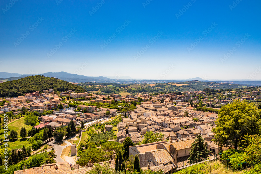 The ancient and beautiful city of Amelia, in Umbria, seen from above. The view of the green Umbrian hills. The mountains in the background. The rich vegetation, the streets and the roofs of the houses