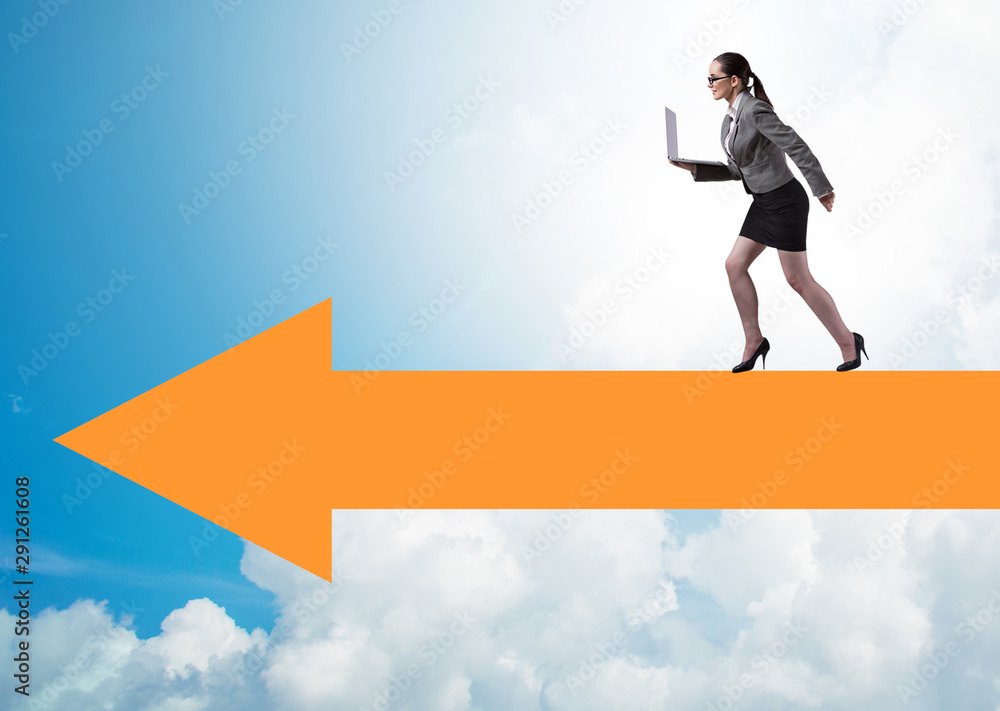 Businesswoman walking on arrow sign Businesswoman walking on arrow sign