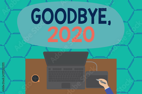 Conceptual hand writing showing Goodbye 2020. Concept meaning New Year Eve Milestone Last Month Celebration Transition Laptop wooden desk worker drawing tablet coffee cup office photo