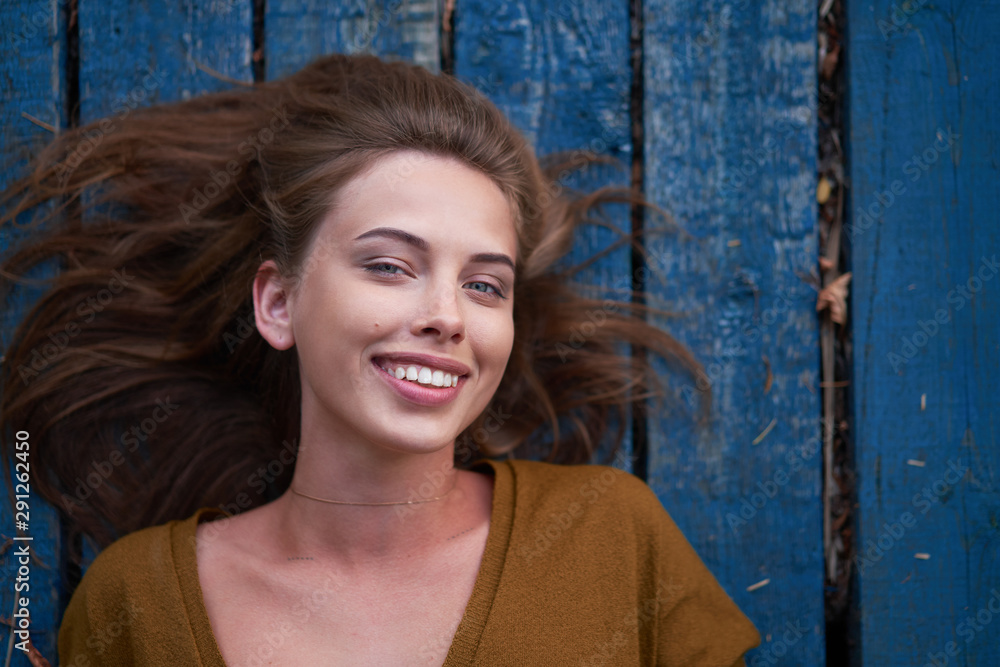 Beautiful caucasian young woman Lying on her back on wooden background. Beautiful caucasian young woman Lying on her back on wooden background.