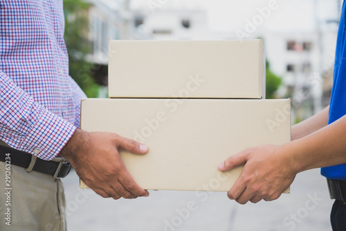 Hand accepting a delivery of boxes from deliveryman. © Nopphon