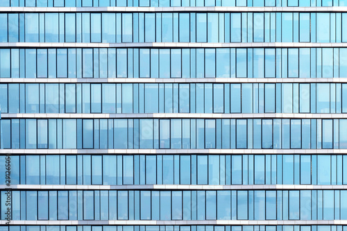 Glass windows of office building, construction background. Blue tones