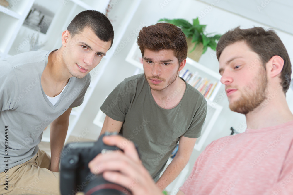 Obraz premium young men checking photos in camera