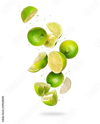 Whole and sliced fresh lime in the air, isolated on a white background