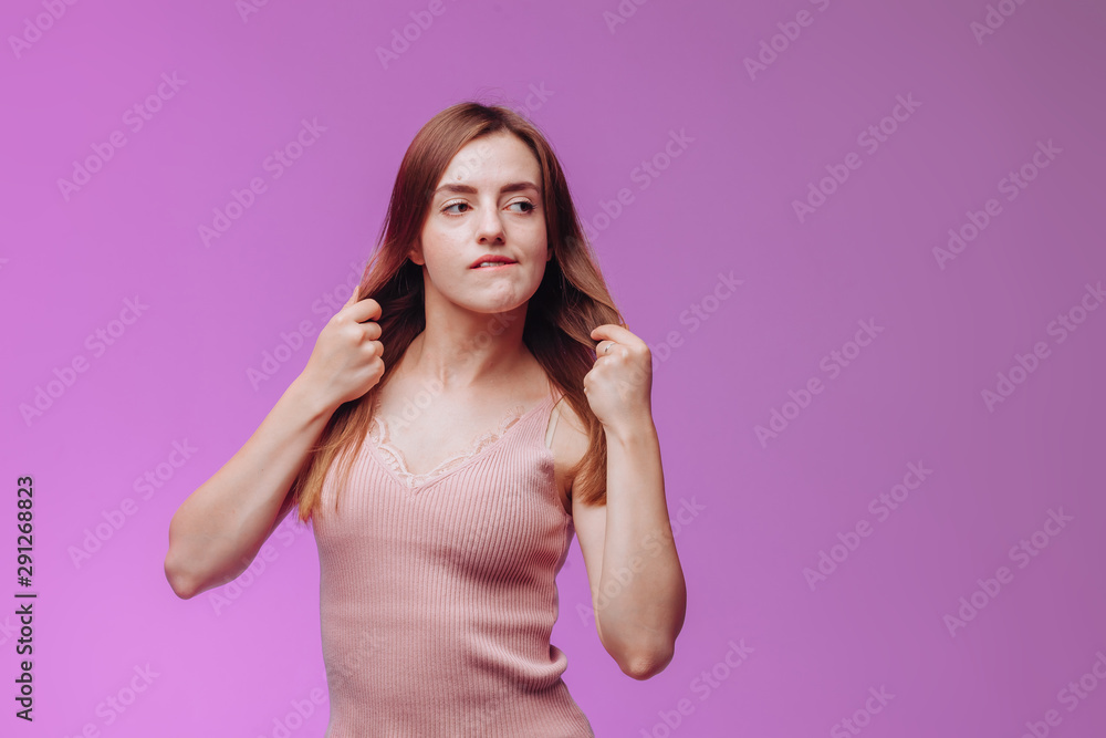 Girl bites her lip on pink background Girl bites her lip on pink background