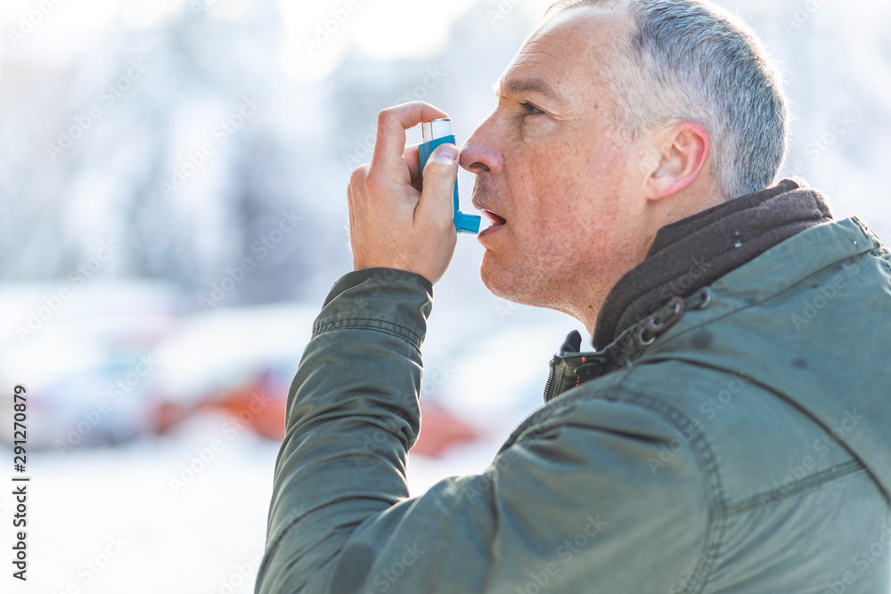 Man uses an inhaler during an asthma attack Man uses an inhaler during an asthma attack