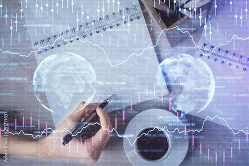 Multi exposure of woman's hands making notes with forex graph hologram. Concept of technical analysis.