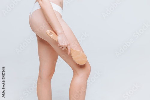 woman doing anti-cellulite massage brush