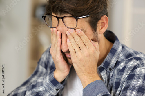 man rubbing his tired eyes photo