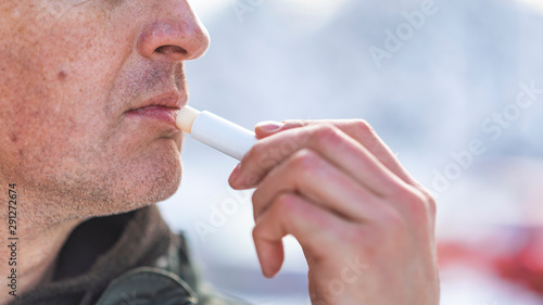 Принти на полотні Handsome, Mature, bearded man using natural lips balm on light gray background