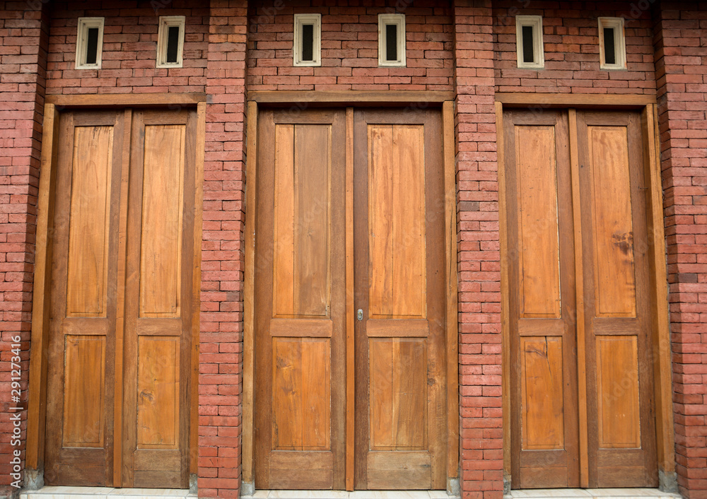 Wooden doors on the wall with a brick pattern Wooden doors on the wall with a brick pattern