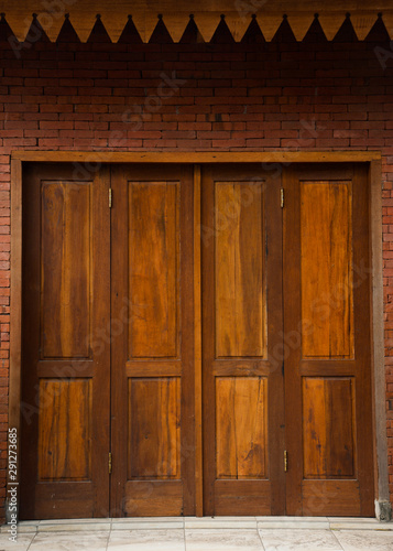 Wooden doors on the wall with a brick pattern © Fajri Hidayat