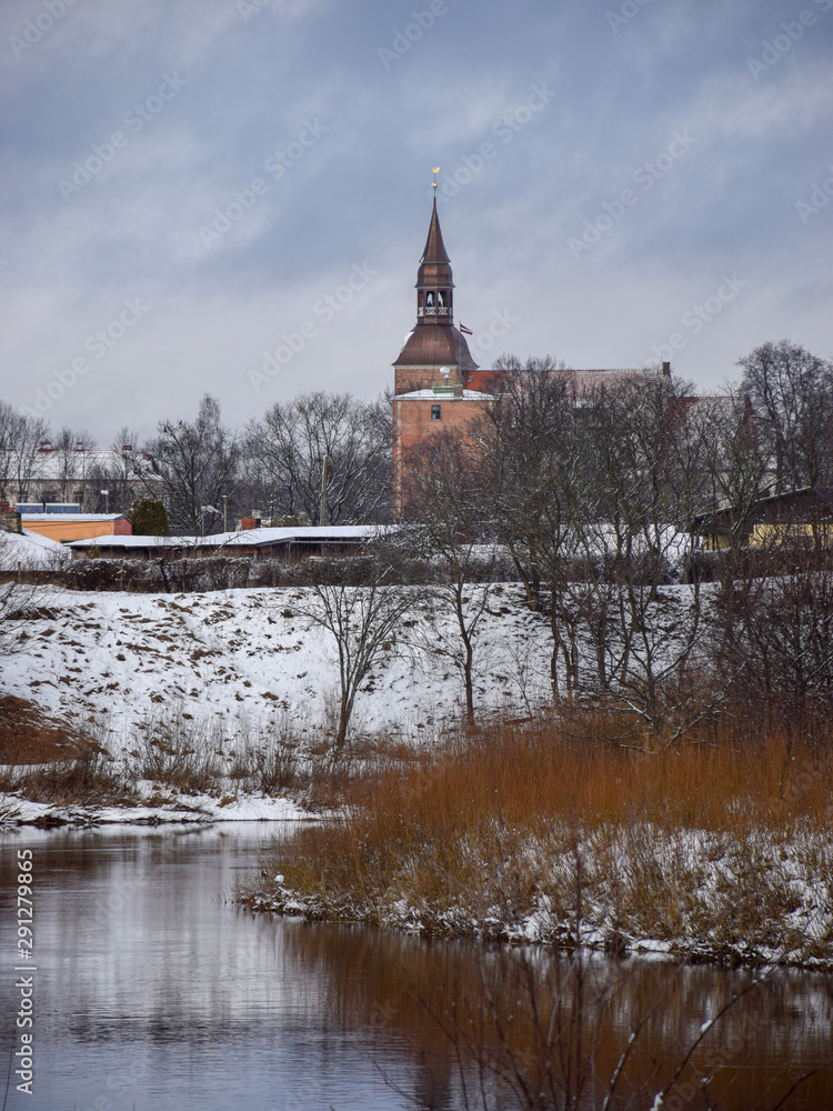 Fototapeta winter landscape with river, city and church tower, Gauja, Sveta Simana church, Valmiera, Latvia