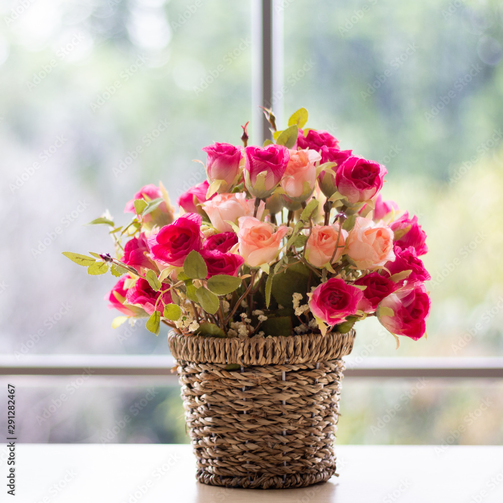 Flowers are in a wooden vase. Placed near the glass window on the wooden table in the room Giving a feeling of being in the spring. Flowers are in a wooden vase. Placed near the glass window on the wooden table in the room Giving a feeling of being in the spring.