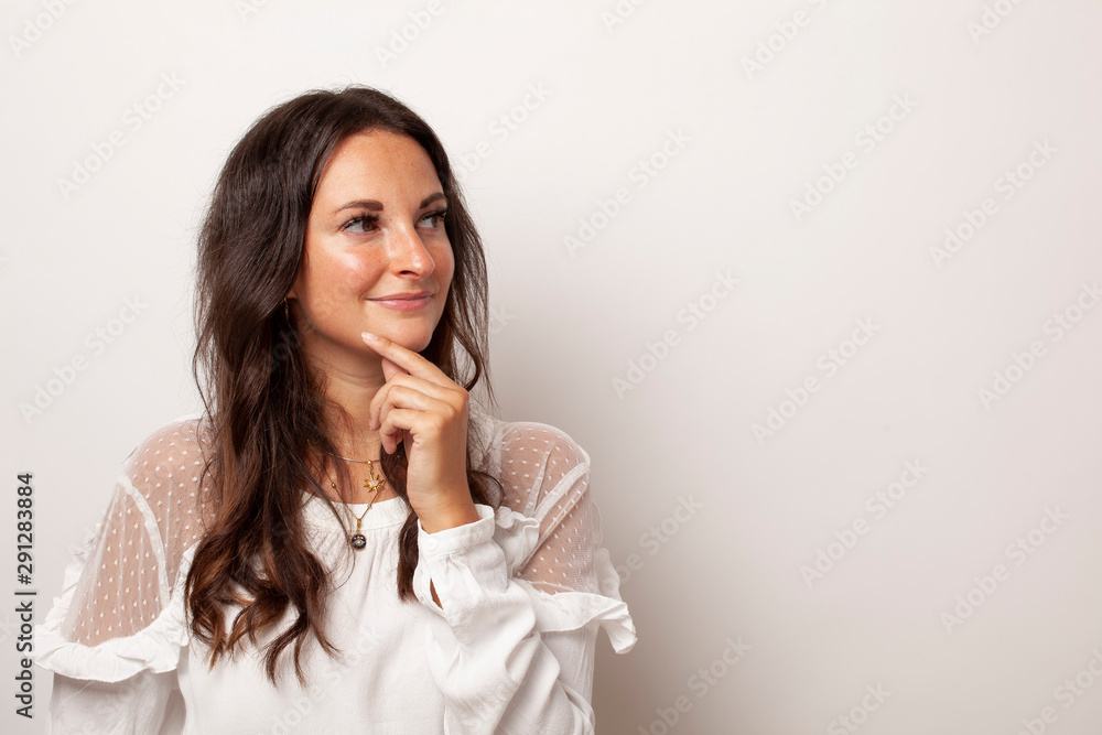 Junge Frau überlegt vor weißem Hintergrund mit Platz für Text oder Werbung Junge Frau überlegt vor weißem Hintergrund mit Platz für Text oder Werbung
