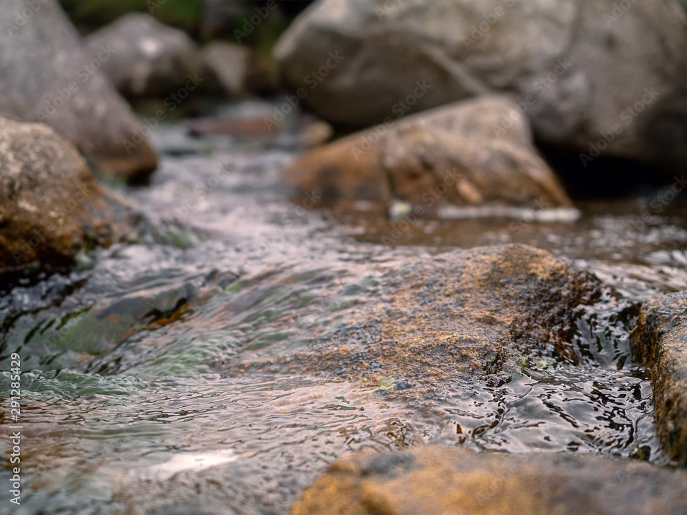 Water stream in a small creek, Brown rocks, Cloudy dramatic sky, Nature background. Water stream in a small creek, Brown rocks, Cloudy dramatic sky, Nature background.