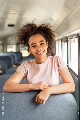African girl sitting inside the school bus posing smiling toothy