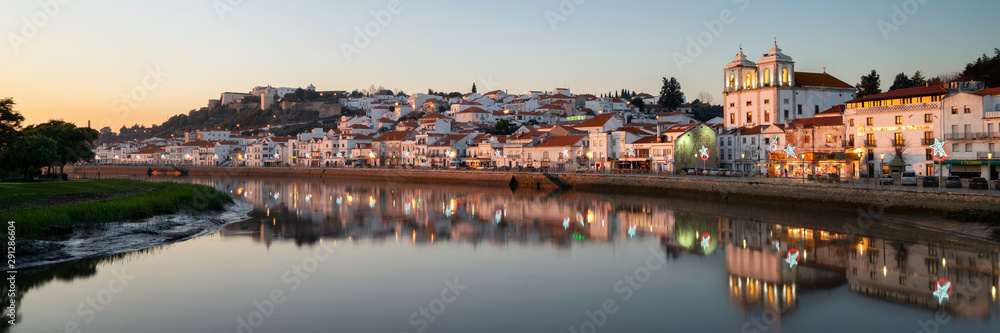 Panorama view of Alcacer do Sal cityscape from the other side of the Sado river at sunset