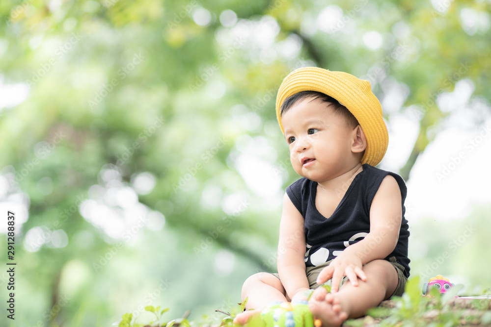Kid boy with yellow hat travel in green city park Kid boy with yellow hat travel in green city park