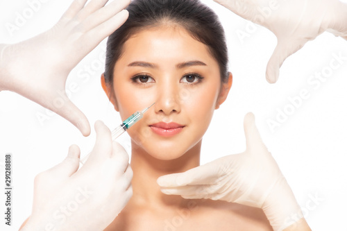 Asain young woman gets injection  in her lips. Woman in beauty salon. plastic surgery clinic.Beautiful woman gets  injection in her face.