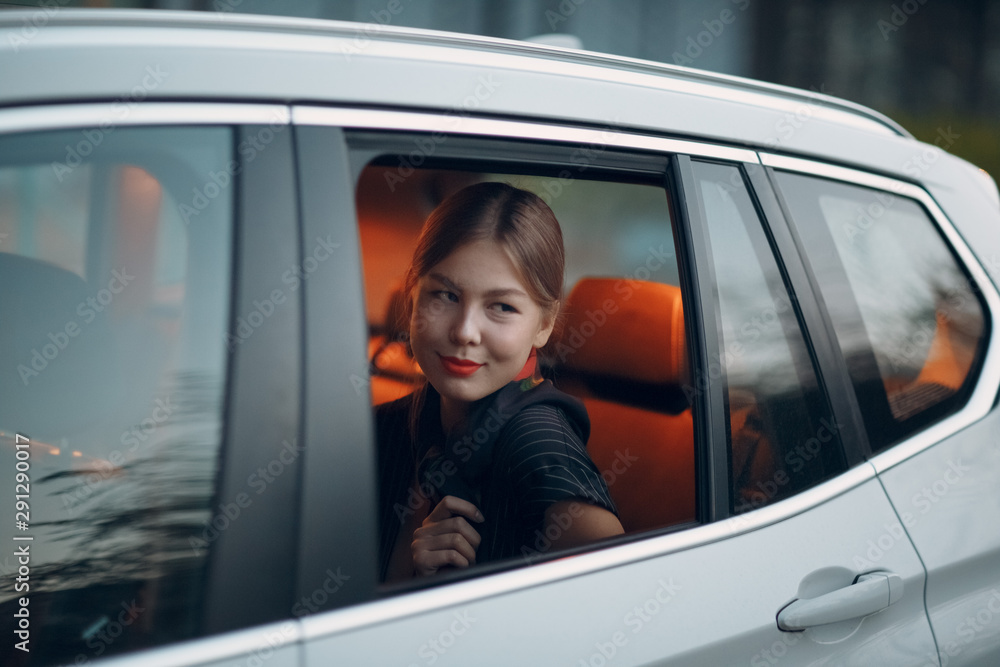 Young smile woman sitting in back seat of car vehicle. Taxi concept.