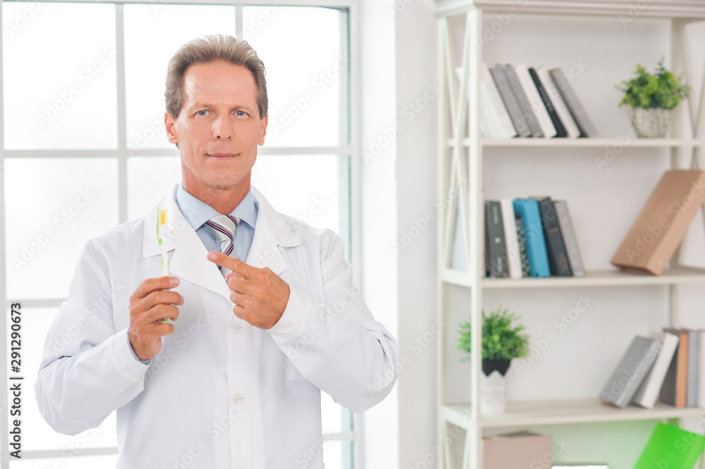 Senior doctor at his office in hospital clean teeth