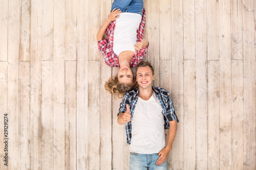 Freestyle. Young man and woman upside down lying on floor showing thumb up smilign cheerful top view