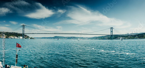 Fototapeta Naklejka Na Ścianę i Meble -  Ferry at harbor with bridge in the background