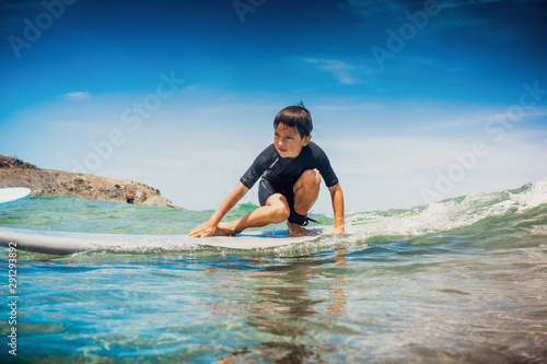 Little boy on top of the body board preparing to ride on the sea wave  Greece